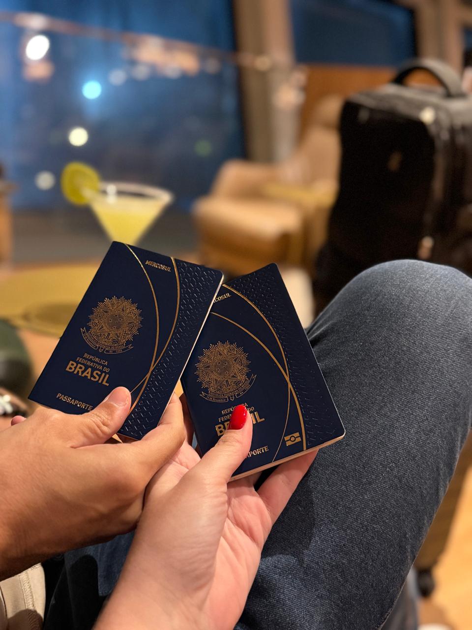Casal segurando passaportes brasileiros em um lounge de aeroporto, antes de embarcar